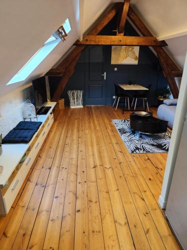 Cette grande chambre dispose de parquet et d'une table. dans l'établissement Le Saut Mur, à Saumur