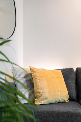 a yellow pillow sitting on a gray couch at Apartment Schoenblick in Caldaro