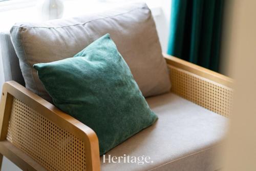 a green pillow sitting on a wicker chair at The Copper Loft Apartment, Keith in Keith
