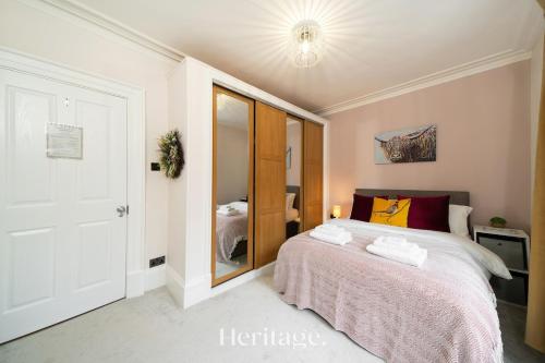 a bedroom with a bed and a mirror at The Copper Loft Apartment, Keith in Keith