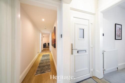 a hallway with a white door and a rug at The Copper Loft Apartment, Keith in Keith
