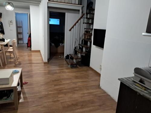ein Wohnzimmer mit Holzboden und einer Treppe in der Unterkunft SA 15min downtown Barcelona, 5min Metro, Beach nearby in Sant Adria de Besos