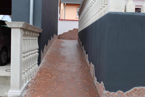 a brick sidewalk next to a blue fence at Gästehaus Mama in Rust