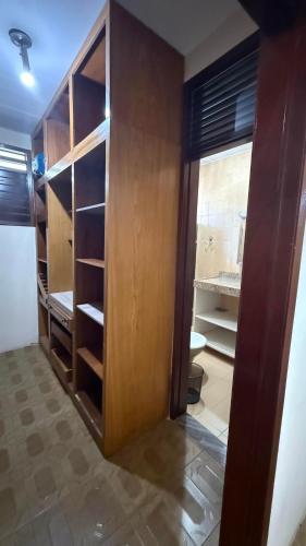a room with a closet with wooden shelves and a door at Casa do Uai in João Pessoa