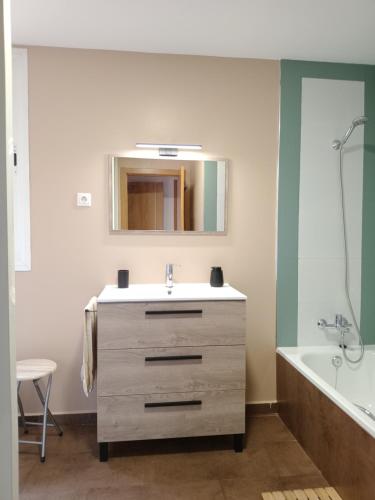 a bathroom with a sink and a mirror and a tub at El Vergel del Piedra in Munébrega