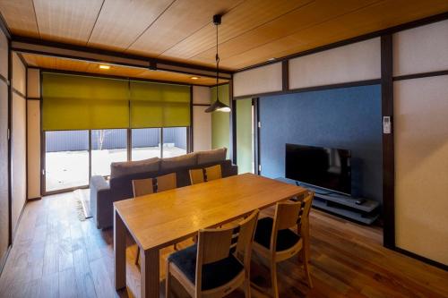 a living room with a wooden table and a television at live takayama in Takayama