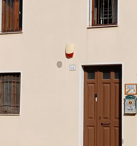 a door in a white wall with two windows at Sardinia Experience in Villamassargia