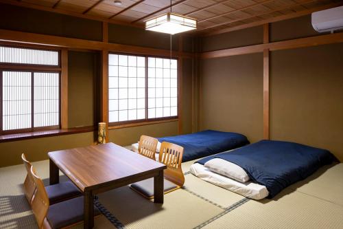a room with a table and a bed and a table and chairs at live takayama in Takayama