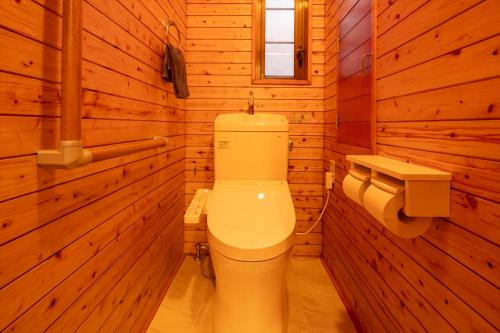 a bathroom with a white toilet in a wooden room at live takayama in Takayama