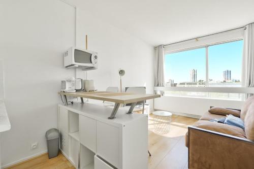 un salon blanc avec une table et un canapé dans l'établissement Beautiful Studio at La Défense near Paris, à Puteaux