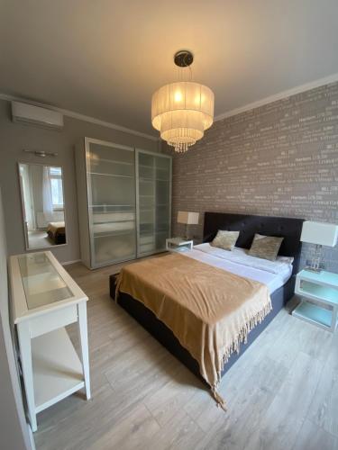 a bedroom with a large bed and a chandelier at Apáczai Apartment nearby Chain Bridge in Budapest