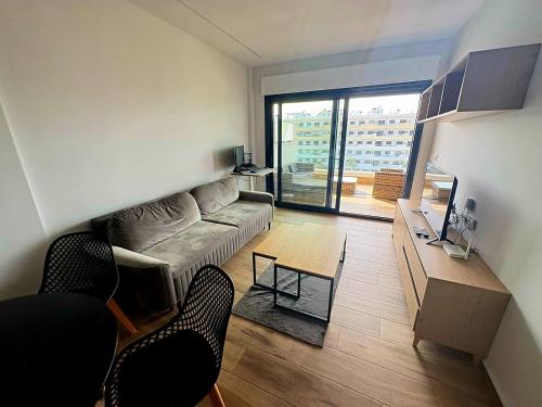 ein Wohnzimmer mit Sofa und Tisch in der Unterkunft Claudia Luxury Apartment near the beach with a pool, gym, and secure gated parking in Arenales del Sol