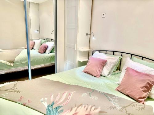 une chambre avec deux lits et un miroir dans l'établissement magnifique 2 pièces parc de la croisette, à Cannes
