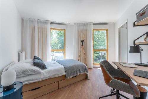 une chambre avec un lit et un bureau avec un ordinateur dans l'établissement Canvas La Défense, à Puteaux