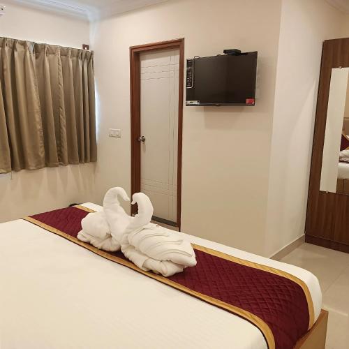 a room with two swans towels on a bed at Hotel Hebron Suites in Bengaluru