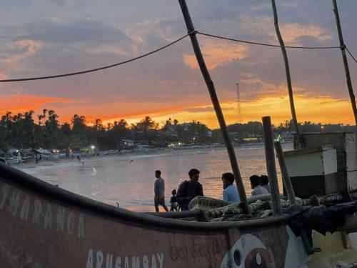 a group of people sitting in a boat on the beach at Kudah Bay Surf Camp in Arugam Bay