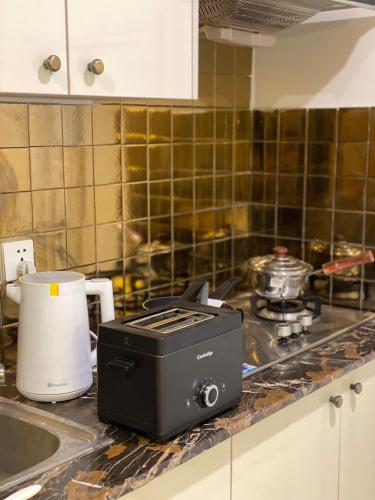 a toaster sitting on a counter in a kitchen at Bohemian Studio Apt Bahria town Lahore in Rāmkot