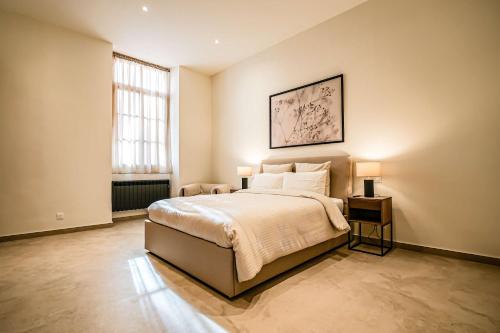 une chambre avec un lit avec deux lampes dessus dans l'établissement Massena Infinity, à Nice