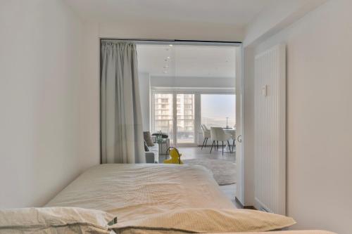 a bedroom with a bed and a view of a dining room at Appartement San Marino 4B in Middelkerke