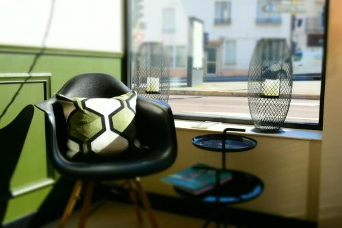 a chair with a soccer ball on it sitting next to a window at L'aparthoteL LhL in Dijon