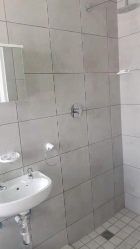 a white bathroom with a sink and a shower at Jacobsdaller #1 in Jacobs Bay