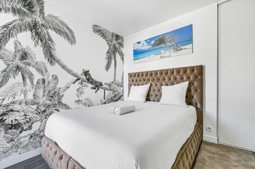 - une chambre avec un grand lit orné d'une fresque murale de palmiers dans l'établissement Le Loft - 8p - Balcon - Salle de Sport - Parking, à Pantin