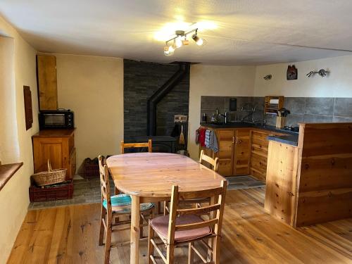 une cuisine et une salle à manger avec une table et des chaises en bois dans l'établissement Jas des Rousses - Champcella, à Champcella
