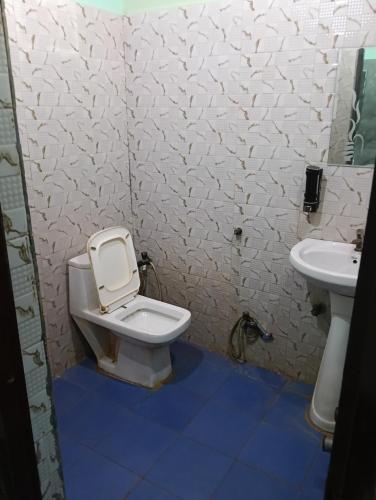a bathroom with a toilet and a sink at PRIYAMVADA FAMILY HOMESTAY in Vrindāvan