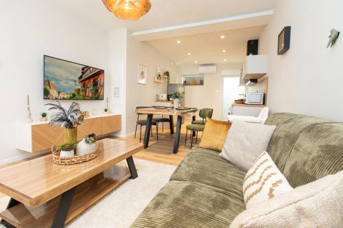 un salon avec un canapé et une table dans l'établissement Colmar Centre - Le Schickele -logement climatisé, à Colmar