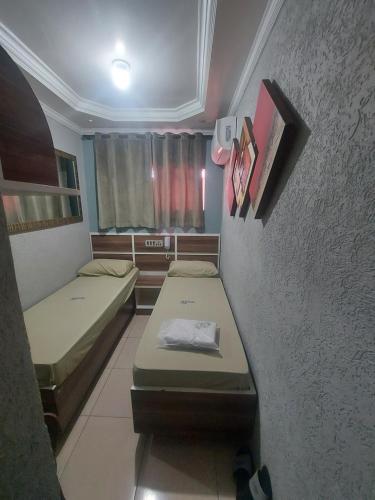 a small room with two beds and a wall at Hotel Luar in Sao Paulo
