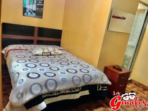 1 cama con edredón en un dormitorio en Hotel & Gemeloz, en Acobamba