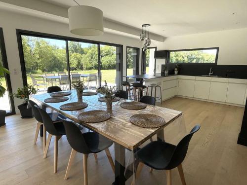 une salle à manger et une cuisine avec une table et des chaises dans l'établissement LesTransatsMarines - Villa Ti Bras, proche Bénodet, superbe maison familiale, à Clohars-Fouesnant