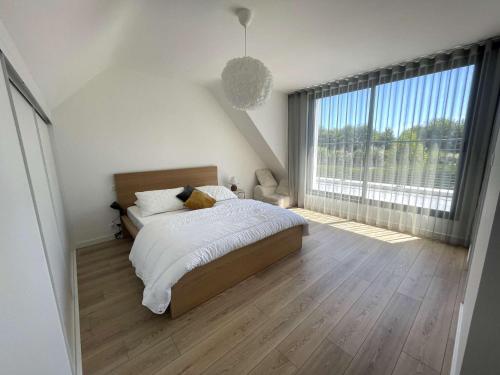 une chambre avec un lit et une grande fenêtre dans l'établissement LesTransatsMarines - Villa Ti Bras, proche Bénodet, superbe maison familiale, à Clohars-Fouesnant