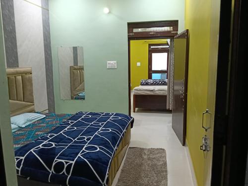 a small room with a bed and a mirror at PRIYAMVADA FAMILY HOMESTAY in Vrindāvan