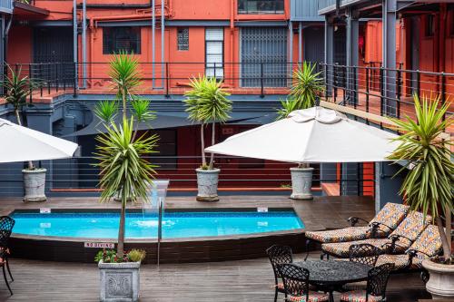 a pool with tables and chairs and umbrellas at Cape Town Lodge Hotel in Cape Town