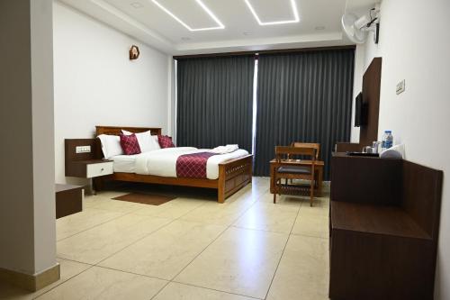 a bedroom with a bed and a desk in a room at Hotel Aamis Villa in Pulpally
