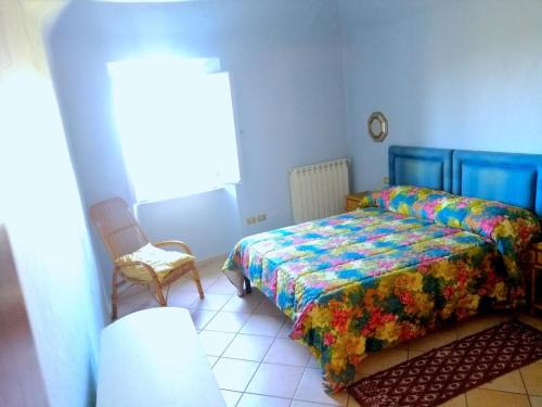 a bedroom with two beds and a chair at Giardino Bellavista Casa Vacanze in Castel del Piano