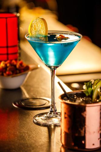 a blue drink in a martini glass on a table at ibis London Blackfriars in London