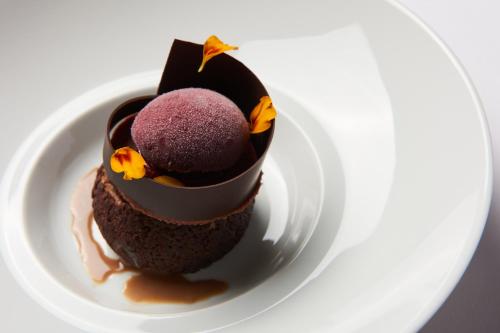 a piece of chocolate dessert on a white plate at Hotel de la Ville Monza - Small Luxury Hotels of the World in Monza