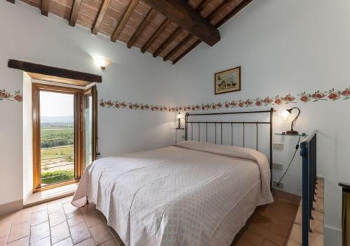 Un dormitorio con una cama y una ventana grande. en La Pieve di San Martino, en Colle Val D'Elsa