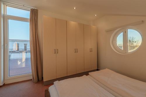 a bedroom with a bed and a large window at Eisvogel Classic 217 in Granzow