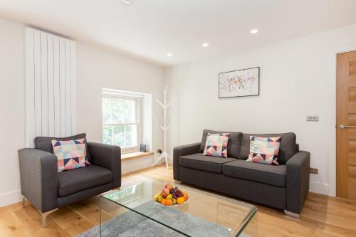 a living room with two couches and a glass table at BnBNova - 2BR 2BA in Fitzrovia & Soho in London