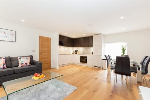 a living room with a black couch and a table at BnBNova - 2BR 2BA in Fitzrovia & Soho in London