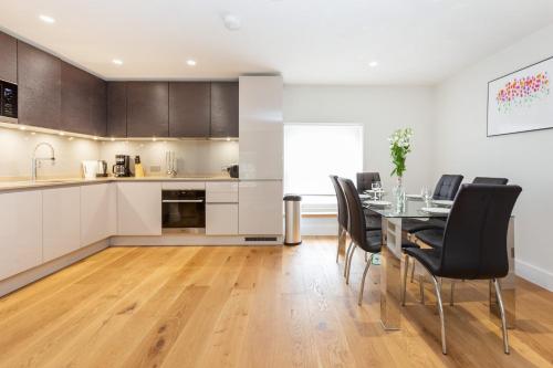 a kitchen and dining room with a table and chairs at BnBNova - 2BR 2BA in Fitzrovia & Soho in London