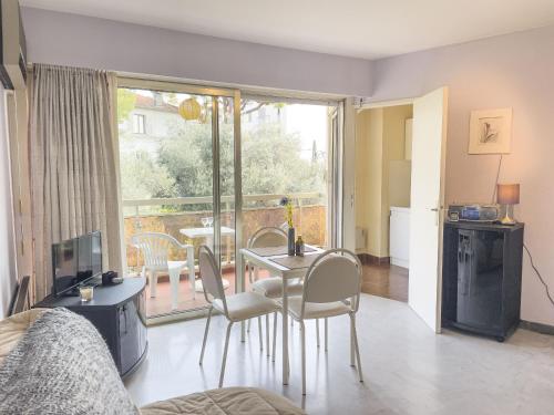 un salon avec une table et des chaises et une fenêtre dans l'établissement Azur Soleil, à Juan-les-Pins