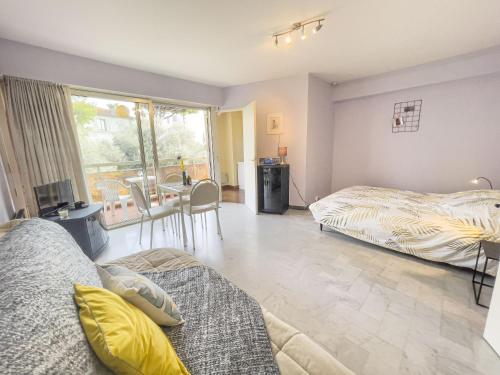 - une chambre avec 2 lits et une table dans l'établissement Azur Soleil, à Juan-les-Pins