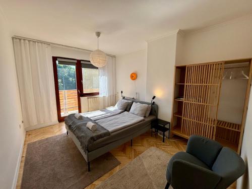 Un dormitorio con una cama y una silla dentro. en Felix Villa, en Nyíregyháza