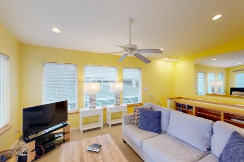 a living room with a couch and a flat screen tv at Hip Nautic in Rockaway Beach