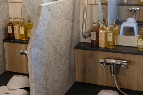 a bunch of bottles of alcohol sitting on a counter in a bathroom at Kyoto Plaza Hotel Kintetsu Jujo in Kyoto