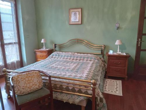 a bedroom with a bed and a chair and two night stands at Bed and Breakfast di Nonna Piera in Casalborgone